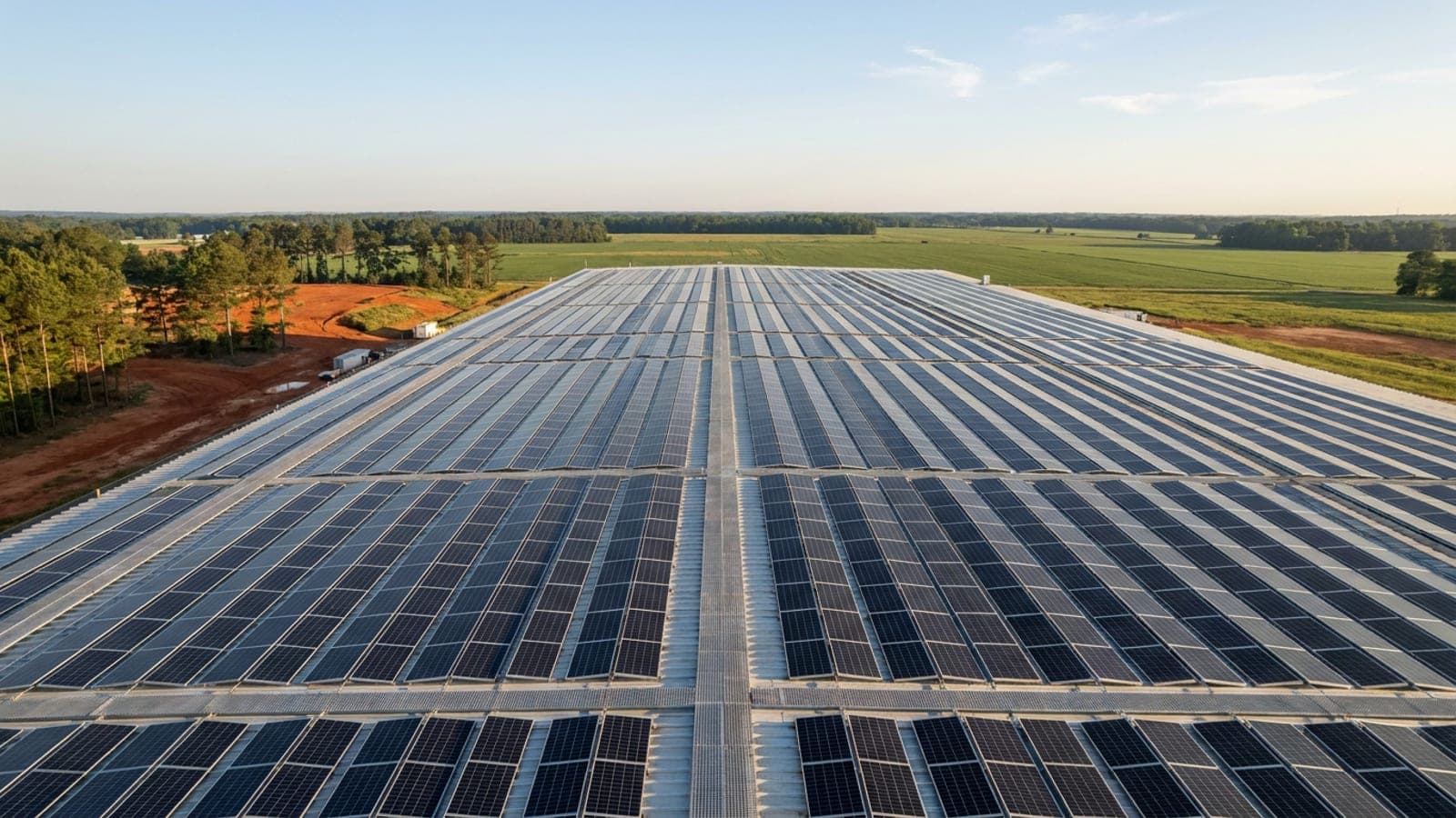 Overhead aerial view of a completed rooftop solar array with service walkways between module rows
